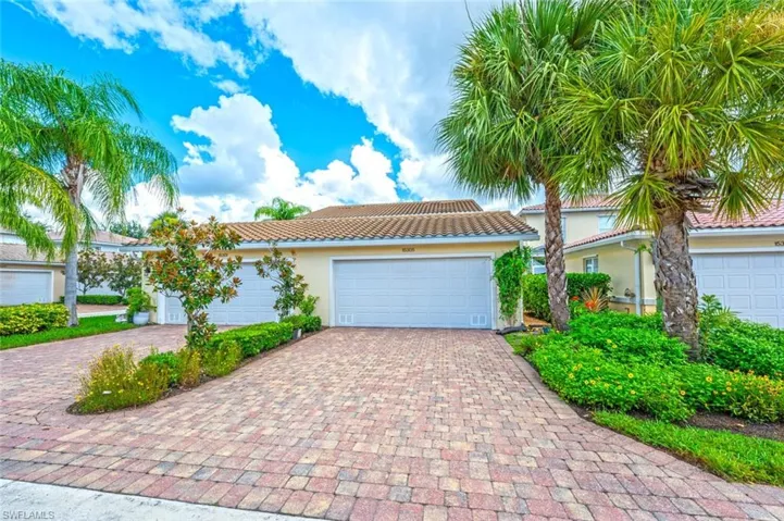 View of front of property with 2 car garage and pavered driveway.
