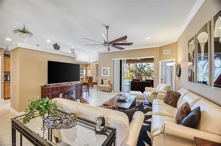 Living area featuring light tile patterned floors, recessed lighting, ceiling fan, and crown molding