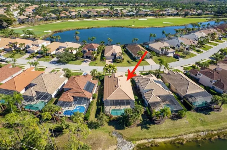 Aerial view of residential area featuring a nearby body of water and a golf club