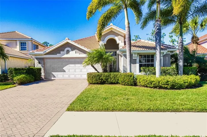 Mediterranean / spanish house with stucco siding, decorative driveway, an attached garage, a front lawn, and a tiled roof