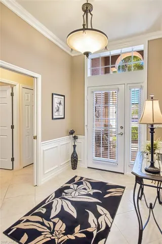 Foyer featuring a wainscoted wall, a decorative wall, and crown molding