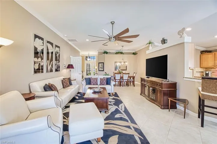 Living area with ornamental molding, ceiling fan, light tile patterned floors, and recessed lighting
