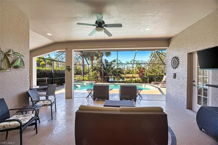 View of patio / terrace with ceiling fan, a sunroom, a lanai, and a pool with connected hot tub