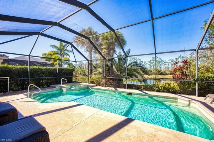 View of swimming pool with glass enclosure, a sunroom, and a pool with connected hot tub