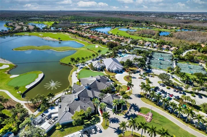 Aerial view of residential area featuring a local golf course and a large body of water