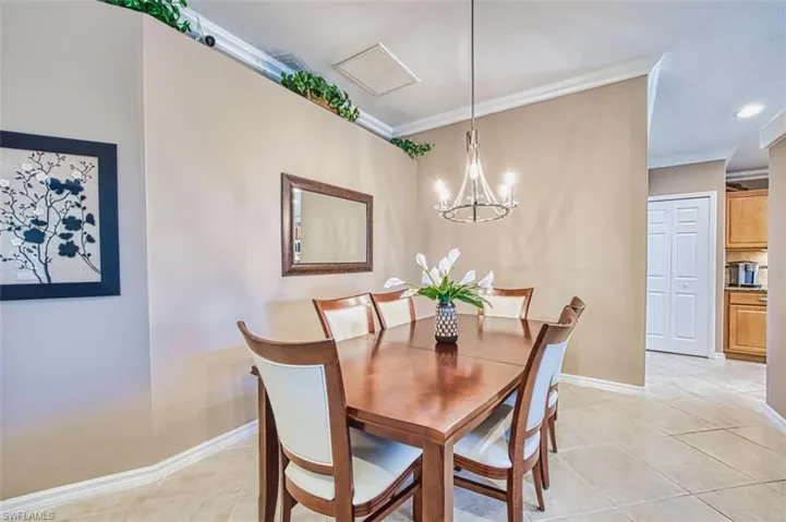 Dining space with ornamental molding, a chandelier, light tile patterned floors, and recessed lighting