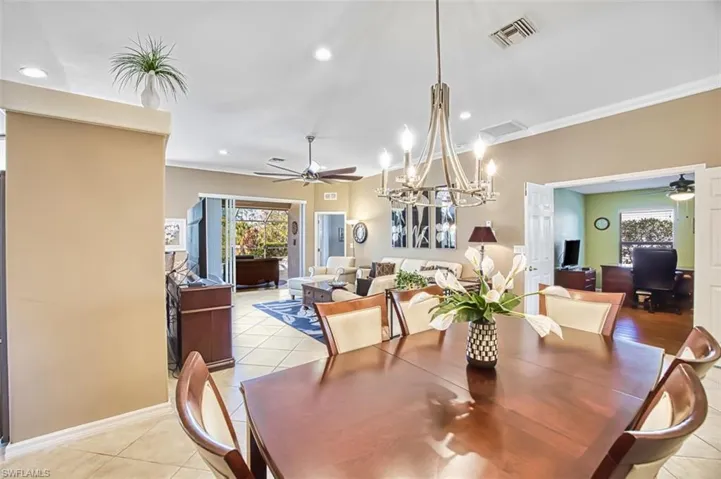 Dining area with ceiling fan, a chandelier, recessed lighting, ornamental molding, and light tile patterned floors
