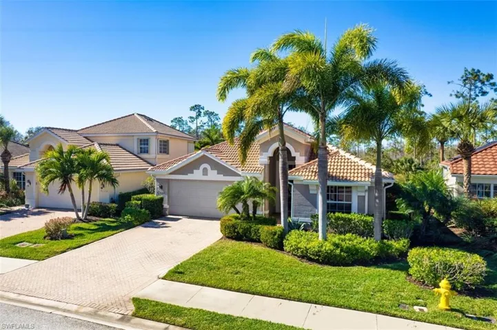 Mediterranean / spanish-style home featuring decorative driveway, a tile roof, an attached garage, stucco siding, and a front yard