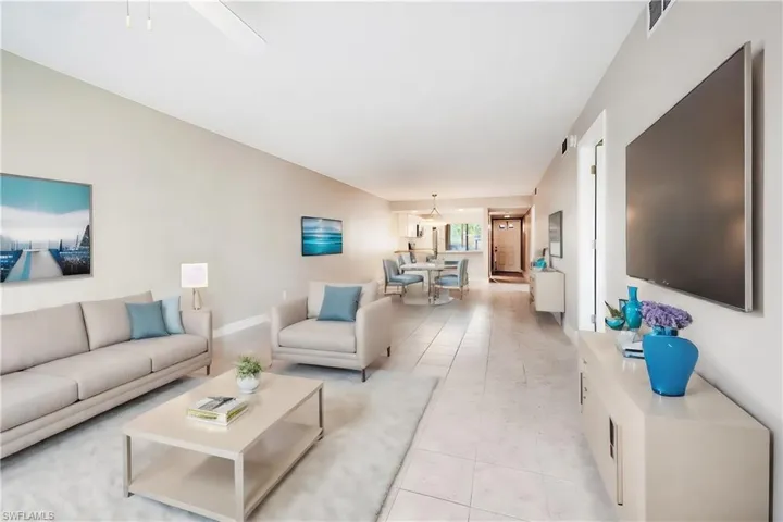 Living room with light tile flooring/virtually staged