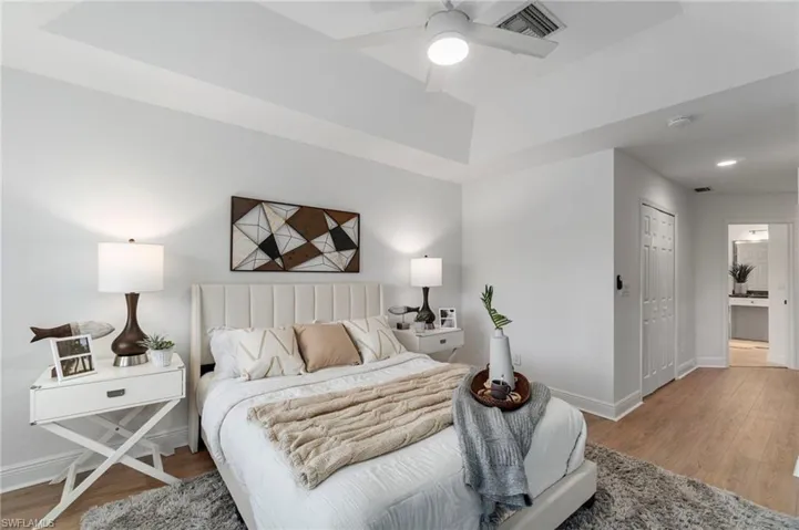 Spacious and bright Primary Suite accented by tray ceiling and hallway to the bath