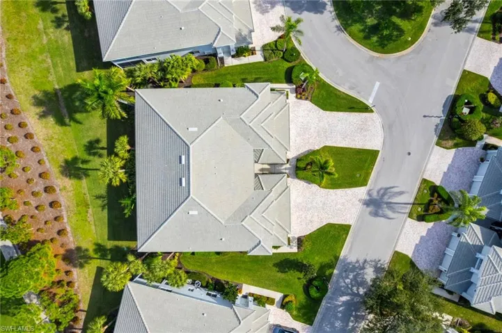 Drone / aerial view of condo building with golf course view and abundant parking.