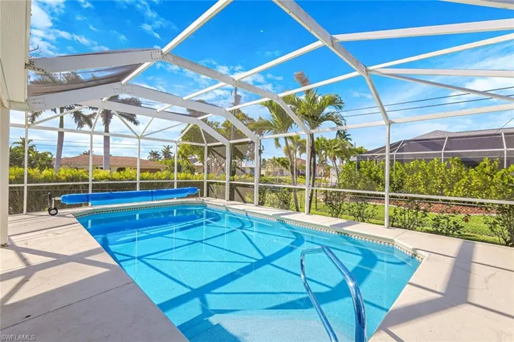 View of swimming pool with glass enclosure, a patio, and a covered pool