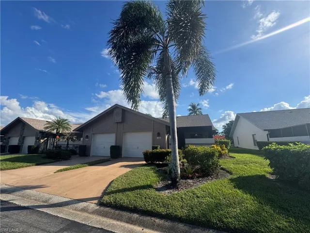 View of property exterior featuring a lawn, driveway, and an attached garage