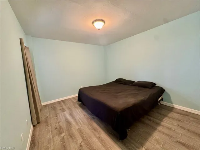 Bedroom with wood finished floors and a textured ceiling