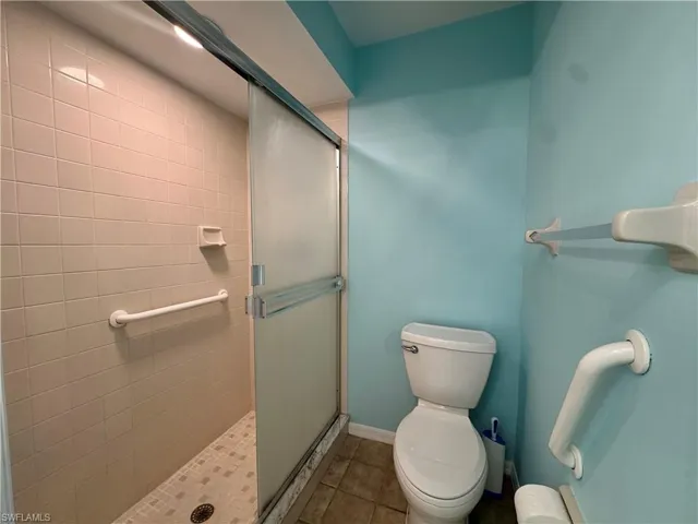 Bathroom featuring tile patterned floors and a shower stall