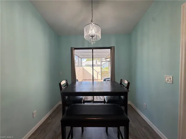 Dining space with dark wood-style flooring and a chandelier