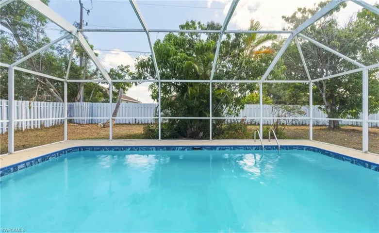 View of swimming pool with a sunroom, a fenced backyard, and a lanai