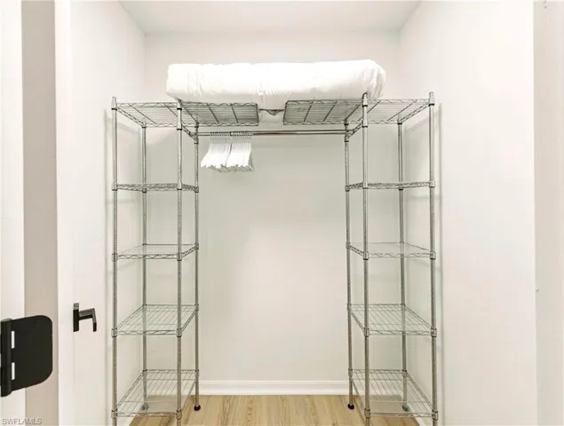Walk in closet with light wood-style flooring