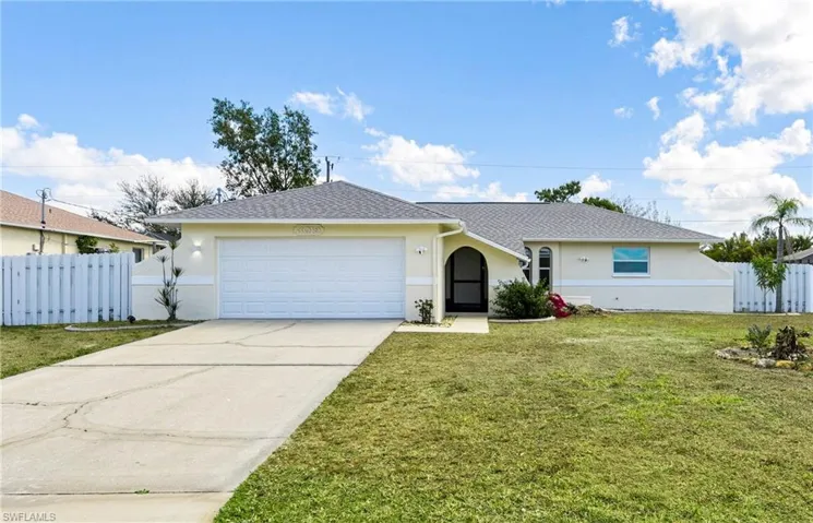 Ranch-style house with driveway, an attached garage, and stucco siding