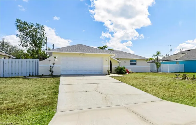 Single story home with stucco siding, a garage, driveway, and roof with shingles