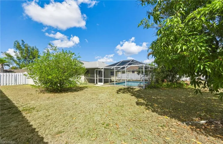 Rear view of house featuring a sunroom, glass enclosure, and a patio