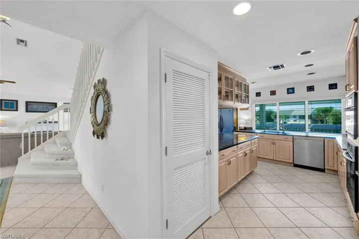 Kitchen featuring light wood cabinetry, dark countertops, and stainless steel appliances