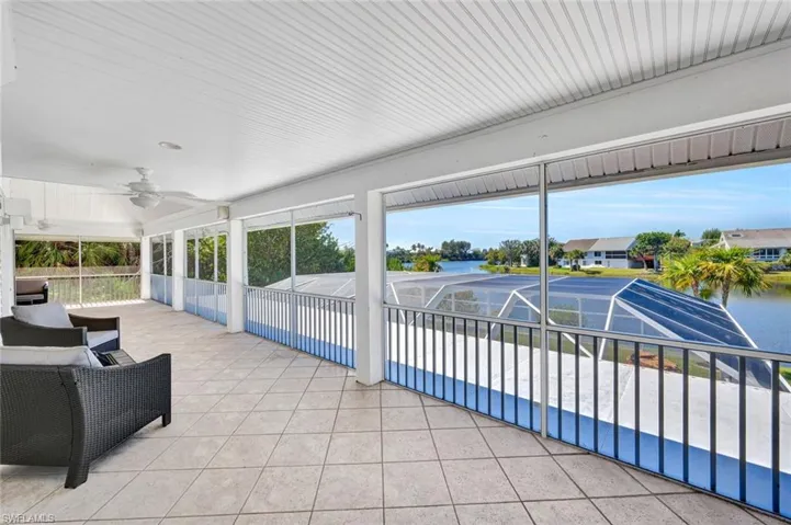 Expansive screened balcony featuring diagonal tile flooring, a slatted ceiling, and an integrated ceiling fan