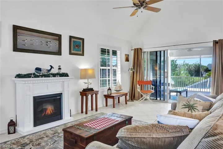 Living area featuring a vaulted ceiling, ceiling fan, and large format tile flooring