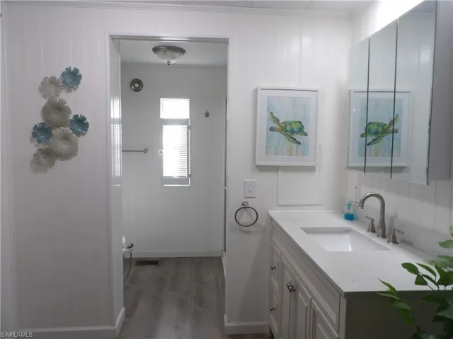 Full view of the primary bathroom with vanity, bidet, luxury vinyl flooring.