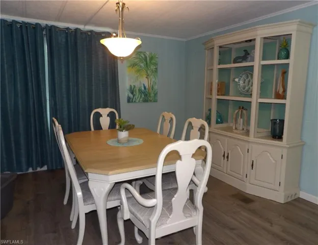 Dining room with crown molding with luxury finished floors