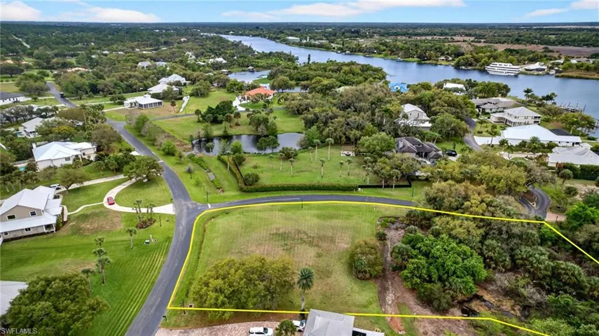 Aerial view of residential area with property parcel outlined and a large body of water