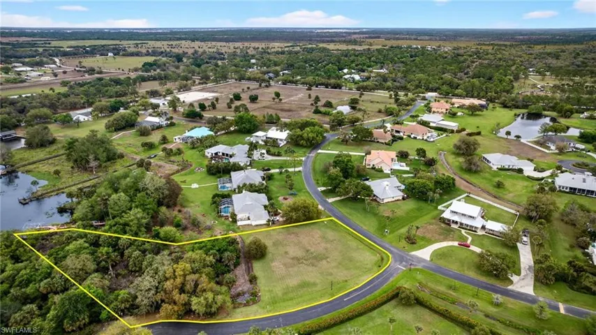 Aerial view of residential area featuring a large body of water and property parcel outlined
