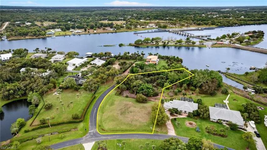Aerial view of property and surrounding area featuring a large body of water and property boundaries highlighted