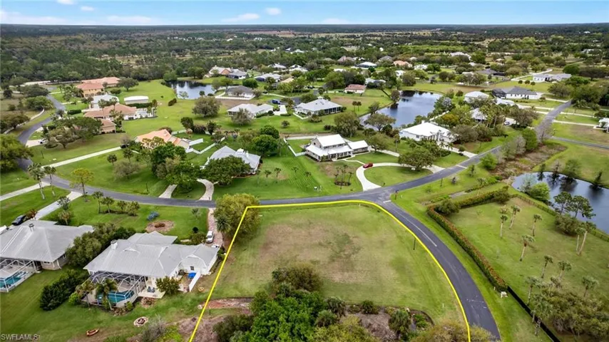 Aerial view of residential area featuring property parcel outlined and a nearby body of water