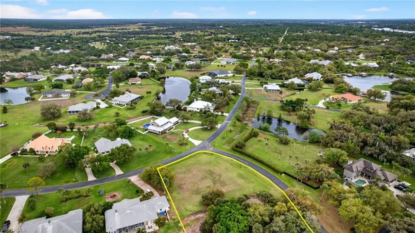 Aerial perspective of suburban area with property boundaries highlighted and a large body of water
