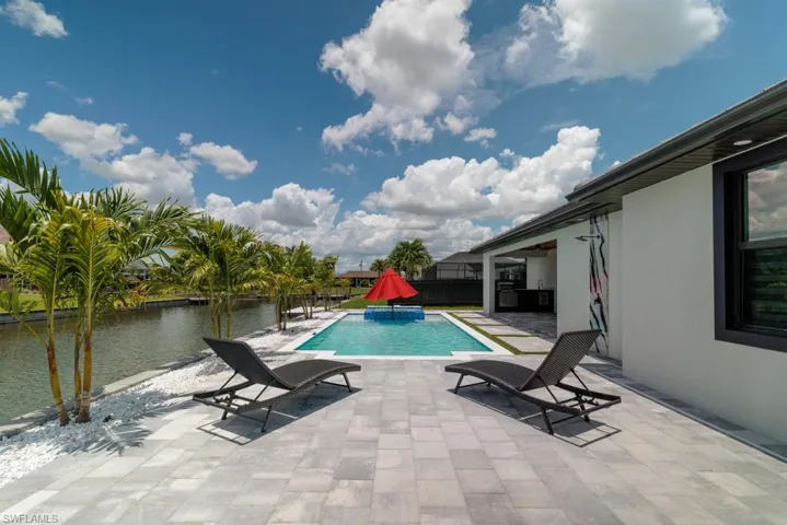 Swimming pool with a patio area and a water view
