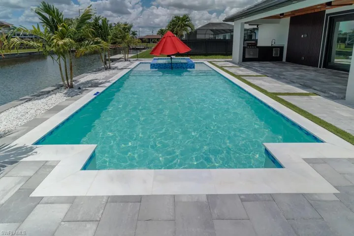 View of swimming pool featuring a patio area and a water view