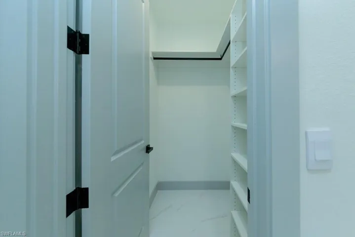 Spacious closet featuring marble look tiles