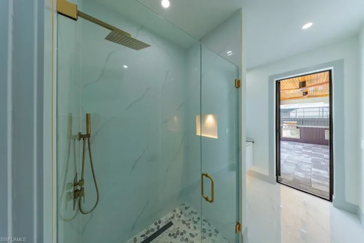 Bathroom with a marble finish shower and recessed lighting