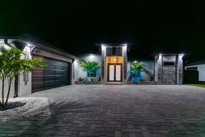 View of front of house with decorative driveway and an attached garage