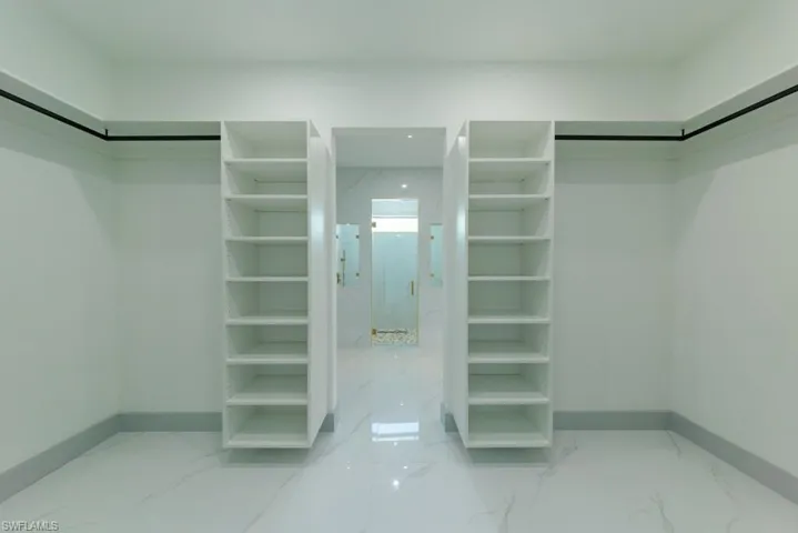 Walk in closet featuring light marble finish floors
