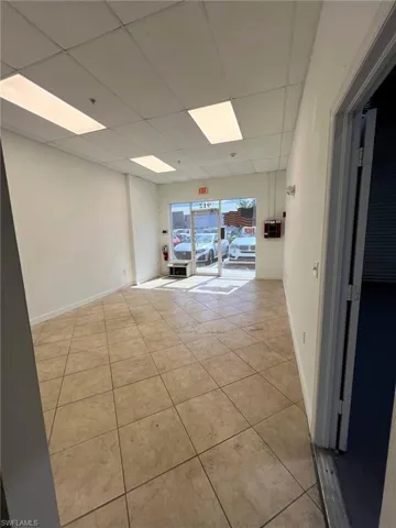 Spare room with light tile patterned flooring and a drop ceiling
