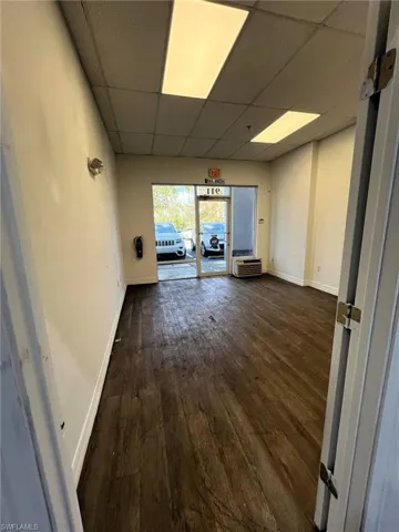 Unfurnished room with dark wood-type flooring and a paneled ceiling