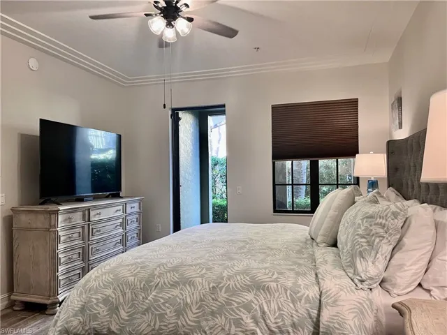 Bedroom with hardwood / wood-style flooring, ceiling fan, and ornamental molding