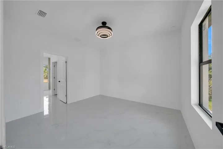 Spare room with light marble finish flooring and baseboards