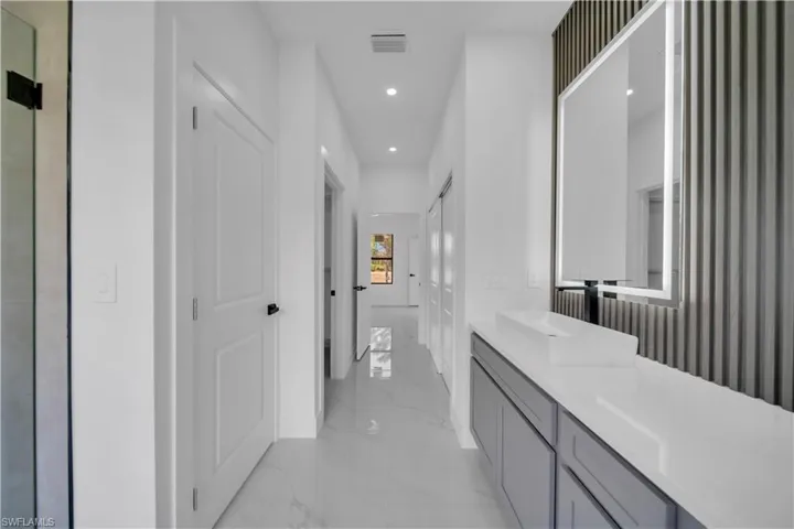 Bathroom featuring vanity, recessed lighting, and light marble finish floors