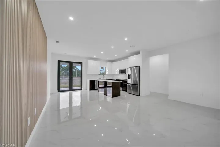 Kitchen with open floor plan, french doors, a center island, recessed lighting, and stainless steel appliances