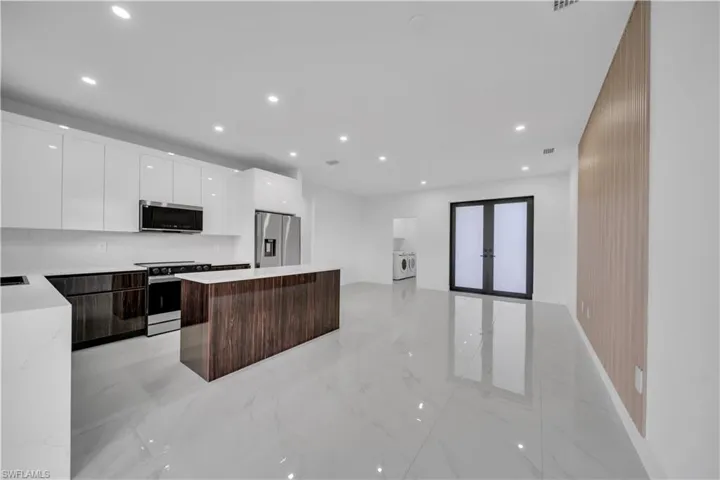 Dual tone kitchen featuring a center island, two tone cabinetry, modern cabinets, stainless steel appliances, and recessed lighting