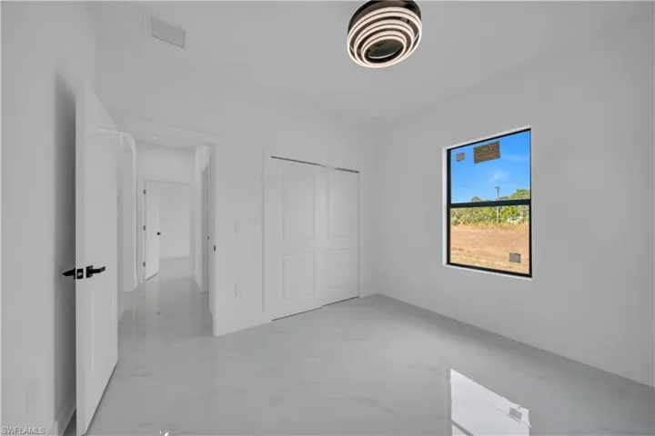 Unfurnished bedroom with a closet and light marble finish flooring