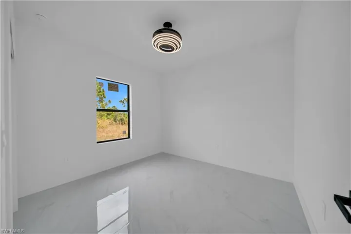 Unfurnished room with light marble finish floors
